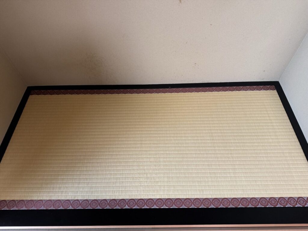 表替え後の床の間の畳。龍鬢表と紋縁で仕上げた。奥の壁にはシミが見える