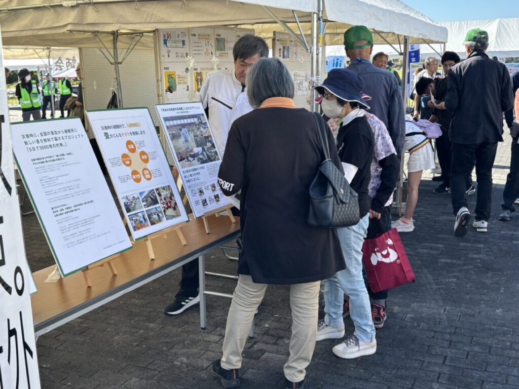 プロジェクトのパネルをご覧になる来場者の方