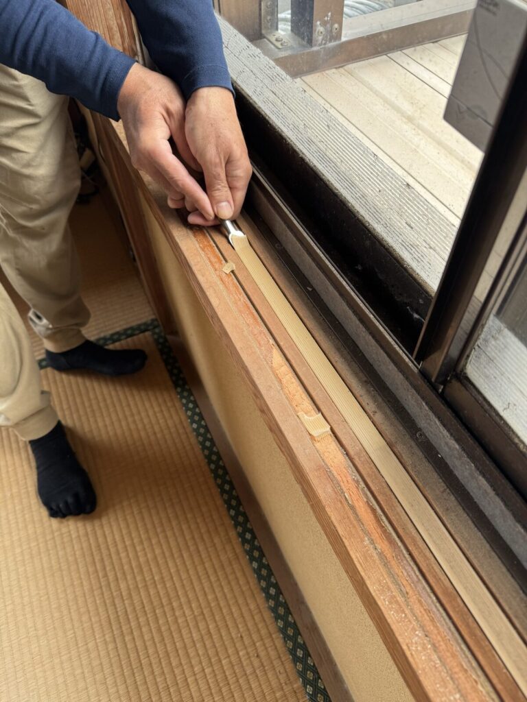 ノミを使って、古い敷居スベリを慎重にはがす