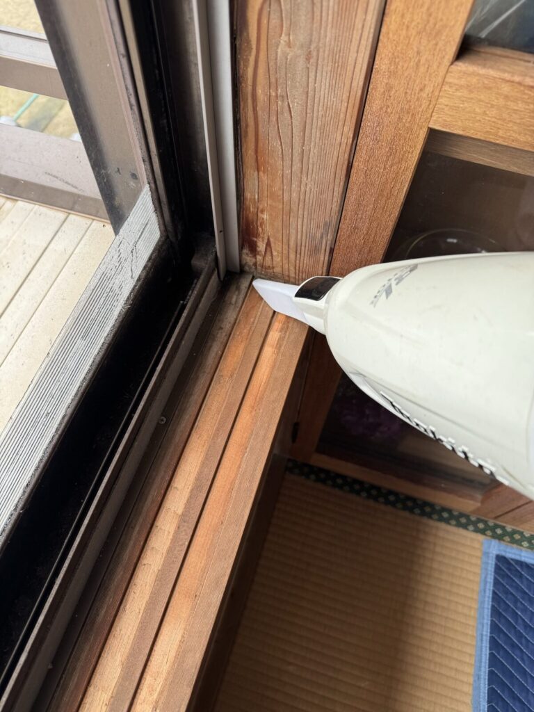 掃除機で、敷居の溝の埃を吸い取る