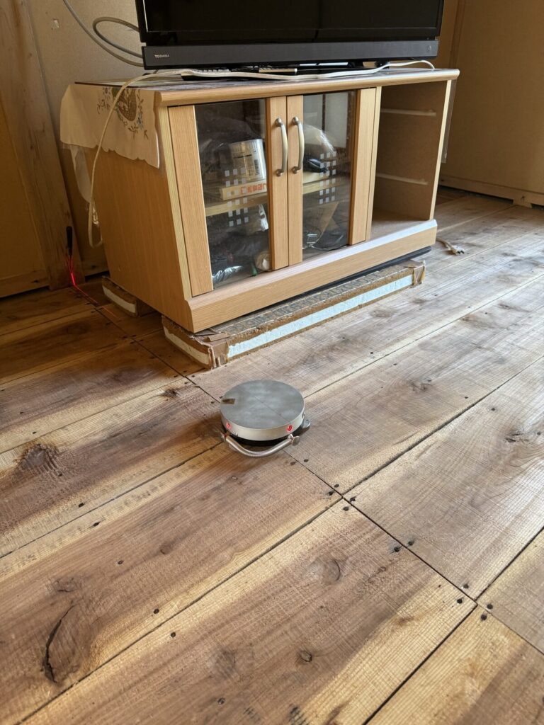 畳を上げた床板の上にレーザーを置いて、お部屋の寸法を測る