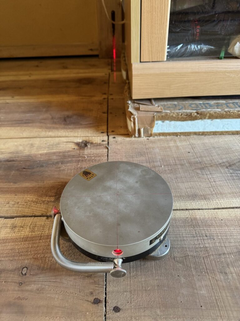 レーザーの赤い光でお部屋の寸法を測っているところ